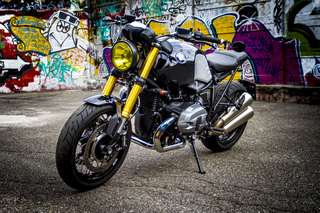 BMW R nineT — Tre quarti anteriore destro, moto intera, muro dipinto alle spalle.