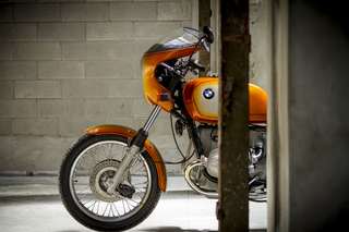 BMW R90 S — Ruota anteriore e parafango, inquadratura stretta contro un pilastro.