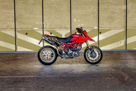 Ducati Hypermotard 1100 — Fiancata destra completa davanti a una vetrata con grafica a chevron.