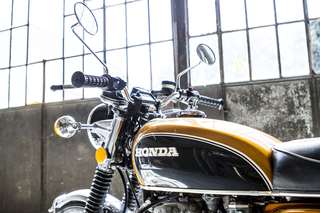 Honda 500 Four — Serbatoio e manubrio da sinistra, specchietto tondo, controluce dalla vetrata.
