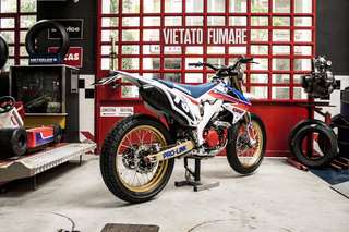 Honda CRF 450 E — In officina, tre quarti posteriore sinistro, moto sul cavalletto da paddock.