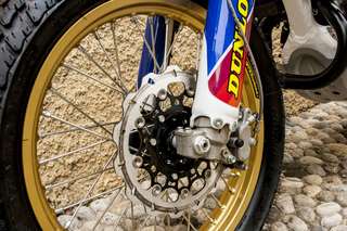 Honda CRF 450 E — In officina, profilo destro sul cavalletto, casco appoggiato alla sella.