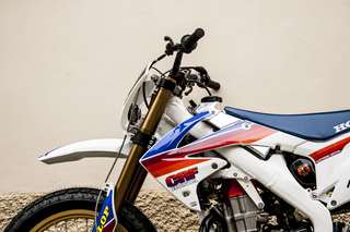 Honda CRF 450 E — Avantreno da sinistra: steli forcella dorati, manubrio, tappo serbatoio in alluminio.