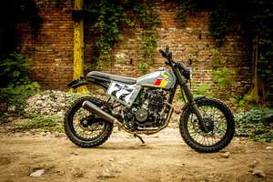 Honda SLR 650 Vigor — Fiancata destra completa davanti a un muro di mattoni coperto d'edera.