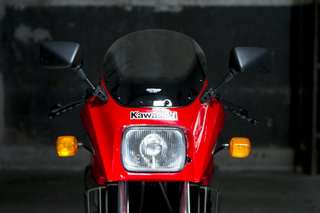 Kawasaki GPZ 900 — Frontale ravvicinato: faro rettangolare, cupolino, specchietti, logo Kawasaki.