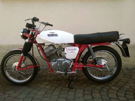 Moto Guzzi Stornello 125 — Fiancata destra completa su pavé, sella lunga e portapacchi posteriore.